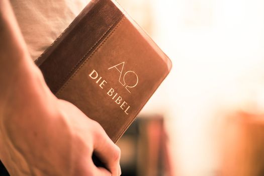 Young preacher is holding the holy bible, praying