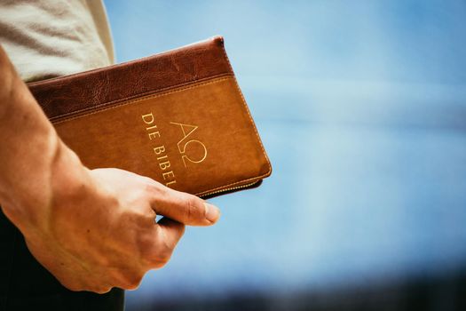 Young preacher is holding the holy bible, praying