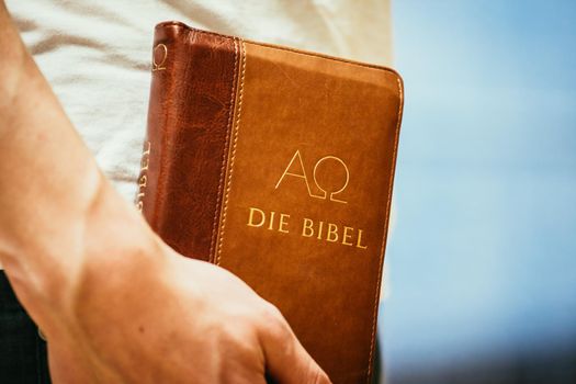 Young preacher is holding the holy bible, praying