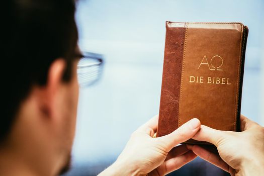 Young preacher is holding the holy bible, praying
