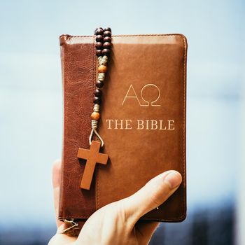 Young preacher is holding the holy bible, praying