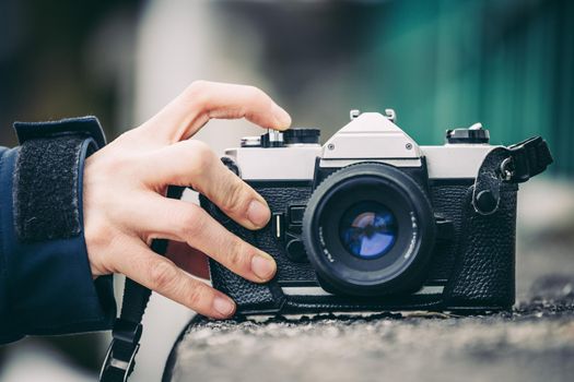 Retro vintage photography camera on a stony wall, outdoors