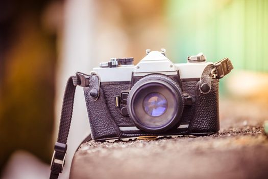 Retro vintage photography camera on a stony wall, outdoors