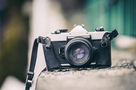 Retro vintage photography camera on a stony wall, outdoors