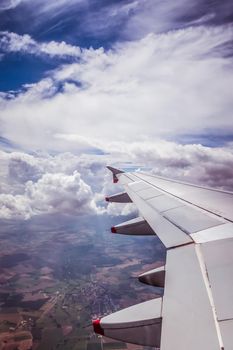 View of a grey airplane wing through the aircraft window. Global warming.