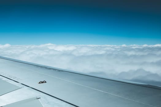 View of a grey airplane wing through the aircraft window. Global warming.