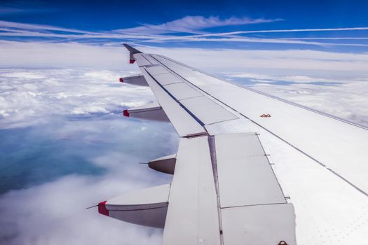 View of a grey airplane wing through the aircraft window. Global warming.