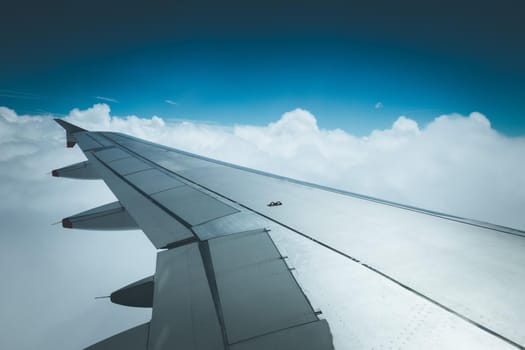 View of a grey airplane wing through the aircraft window. Global warming.