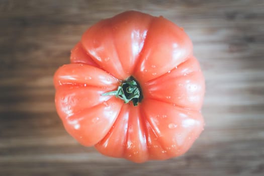 Close up picture of oxheart tomato on a bamboo wood plate.