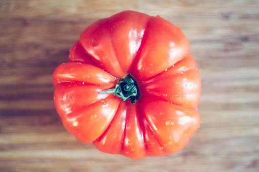 Close up picture of oxheart tomato on a bamboo wood plate.