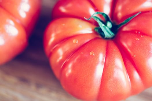 Close up picture of oxheart tomatoes on a bamboo wood plate.