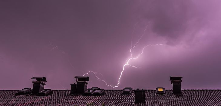 Lightning on the colored sky, roof of a building