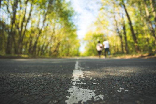 Asphalted street in the forest: Close up perspective, blurry background