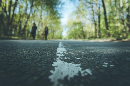 Asphalted street in the forest: Close up perspective, blurry background