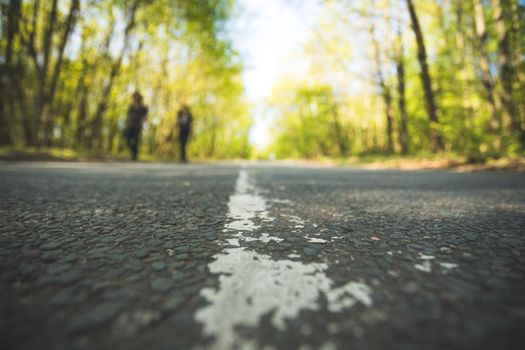 Asphalted street in the forest: Close up perspective, blurry background