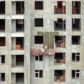 High buildings with scaffold at the construction site, painting a wall