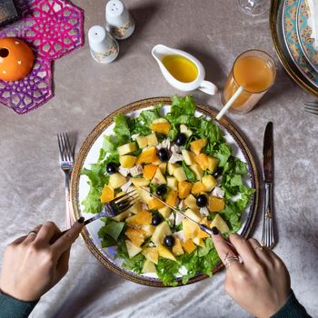 Woman eating tasty pumpkin salad top view