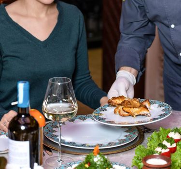 Waiter serving a chicken meat to the woman