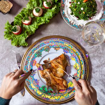 Woman eating chicken meal on the table top view