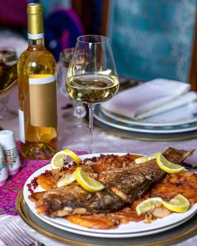 Grilled whole fish with a lemon and white wine close up