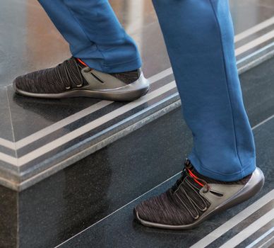 Man black sport sneakers on the stairs close up