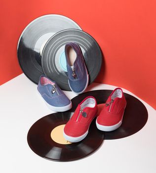 Colorful kids sport shoes isolated red background