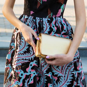 Woman holding a golden handbag close up