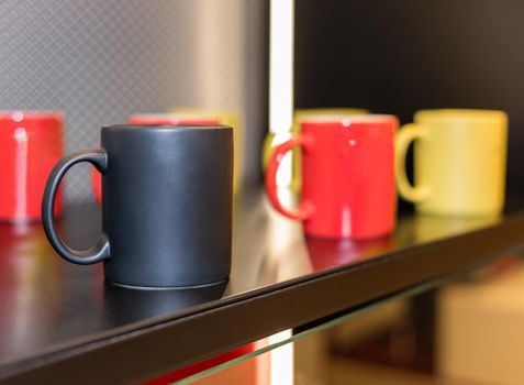 Colorful cups on the showcase close up