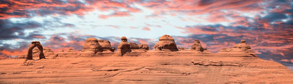 Delicate Arch panoramic view, Arches National Park. High resolution image of rock formations at sunset.