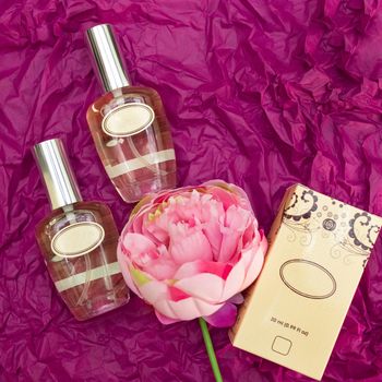 Perfume flacon with rose on the colorful background