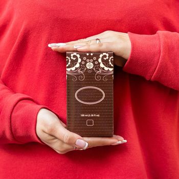 Woman holding perfume flacon box with red cloth