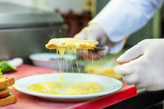 Chef in restaurant kitchen holding tasty cheesy bread