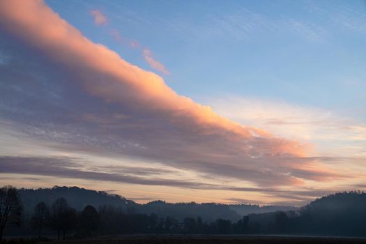 Early morning landscape with pastel-colored clouds