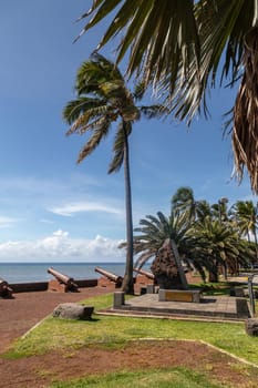 Old cannons and palm tree at the waterfront of Saint Denis on Reuinion island in the Indian Ocean