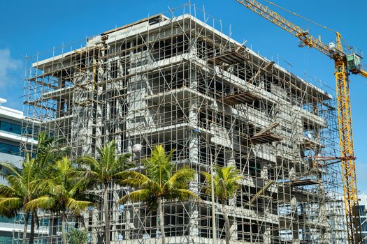 High building under construction with scaffolding and building crane in Port Louis and  on Mauritius island, africa