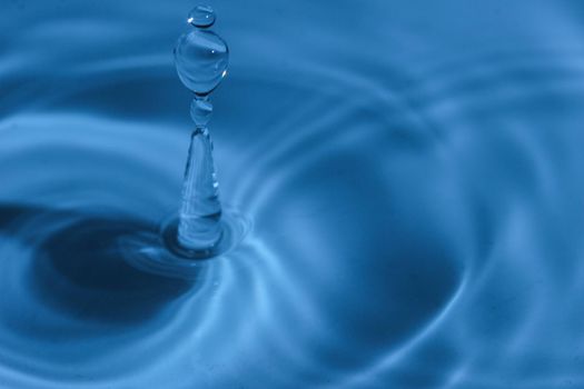 Texture, background with falling water drops and waves with blue water 