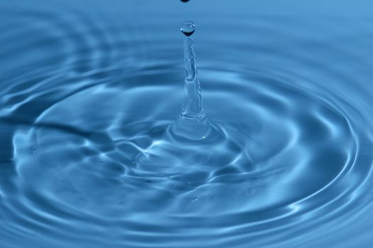 Texture, background with falling water drops and waves with blue water 