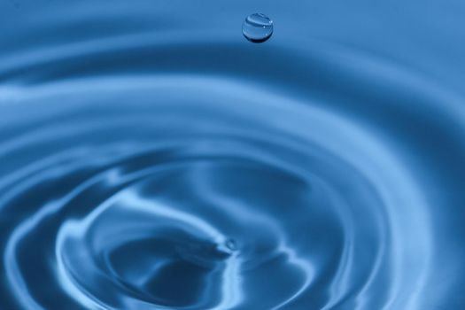 Texture, background with falling water drops and waves with blue water 