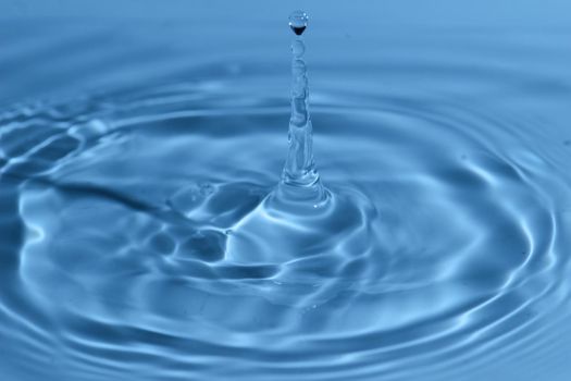 Texture, background with falling water drops and waves with blue water 