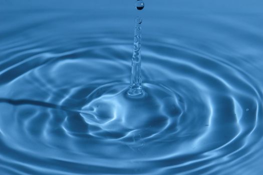 Texture, background with falling water drops and waves with blue water 