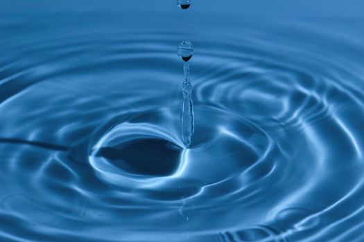 Texture, background with falling water drops and waves with blue water 