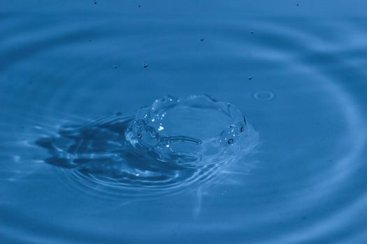 Texture, background with falling water drops and waves with blue water 