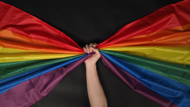 LGBTQ flag or Lesbian Gay Bi sexsual Transgender Queer or homosexsual pride Rainbow flag on black background. Represent hand symbol of freedom, peace, equality and love. LGBTQ concept