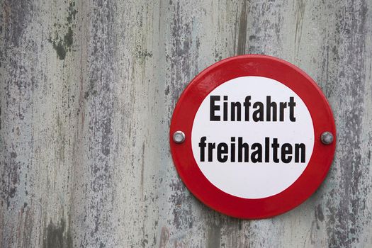 Information sign with the German words "Einfahrt freihalten" translates into "Keep gateway clear" in English language