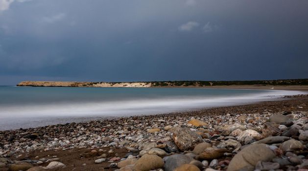 Sandy and pebble beach of the Mediterranean Sea, shot in calm weather at night with a long exposure.