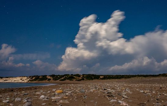 Sandy and pebble beach of the Mediterranean Sea, shot in calm weather at night with a long exposure.