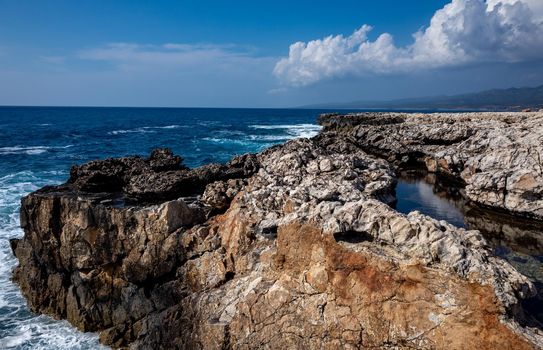 Waves crash on the rocky shore of the Mediterranean Sea on the Akamas Peninsula in the northwest of the island of Cyprus.