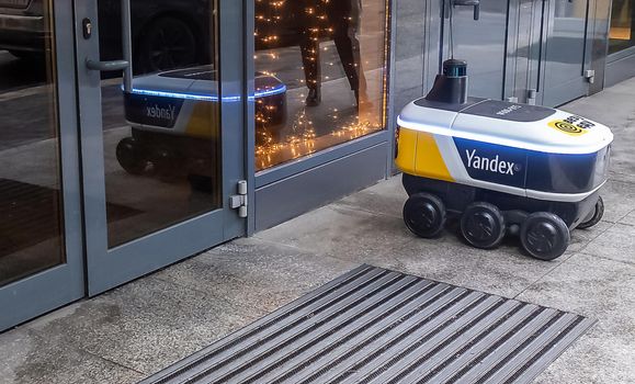 December 14, 2020, Moscow Russia. An unmanned robot courier for delivering food from the Yandex.Rover cafe at the entrance to a restaurant in Moscow.
