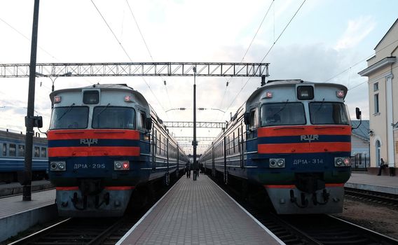 May 5, 2015 Baranovichi, Belarus. Two suburban electric trains near the platform of the Baranovichi railway station on a warm spring evening.