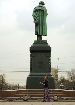 April 21, 2012, Moscow, Russia. A girl with a book at the Pushkin monument in Moscow.